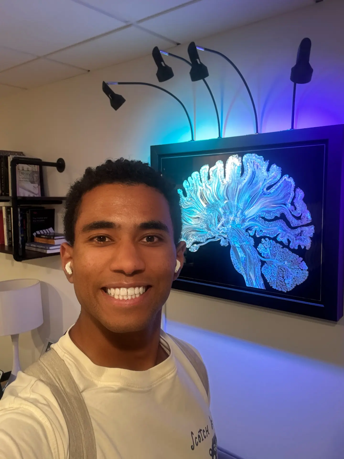 Orion Goodman standing beside a lit sagittal-section brain artwork.